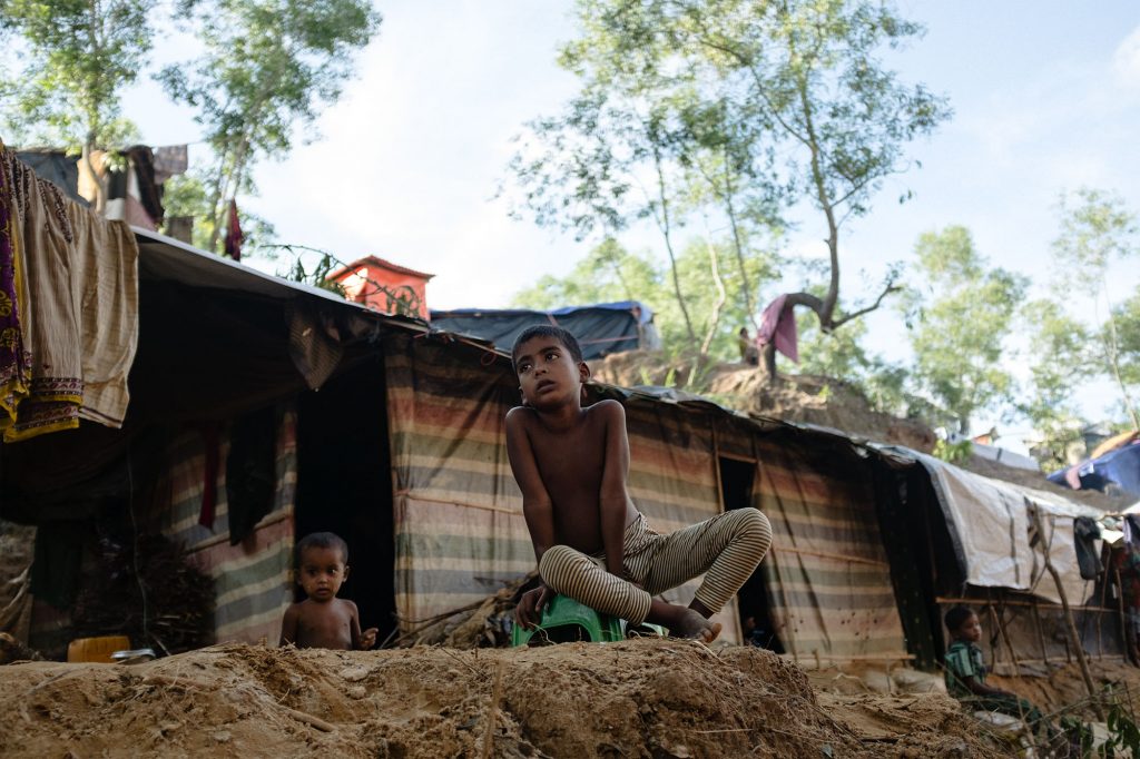 Kinder sitzen vor einer improvisierten Unterkunft in einem Rohingya-Flüchtlingscamp, Bangladesch, 2017.